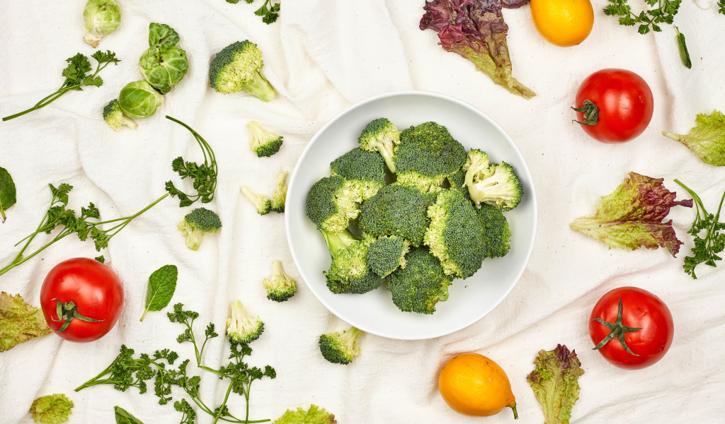 Брокколи на столе с помидорами и зеленью