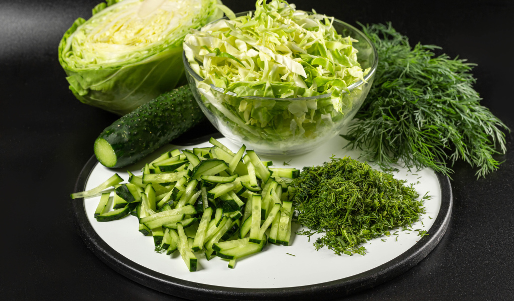 Салат с капусты на столе с огурцами и укропом 