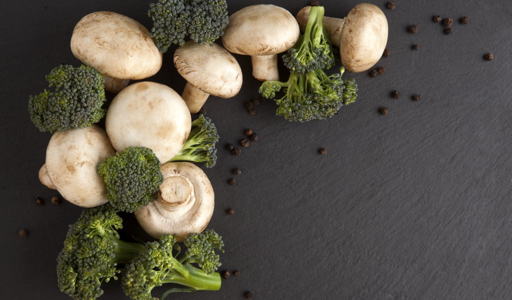Шампиньоны с брокколи на сером столе 