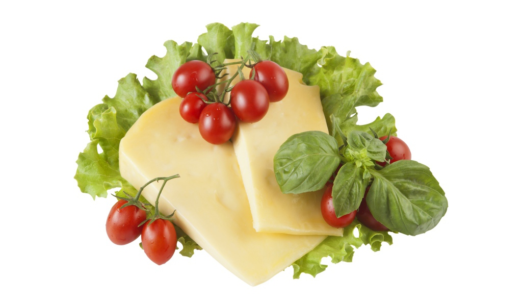 Сыр с помидорами, листьями салата и базиликом на белом фоне