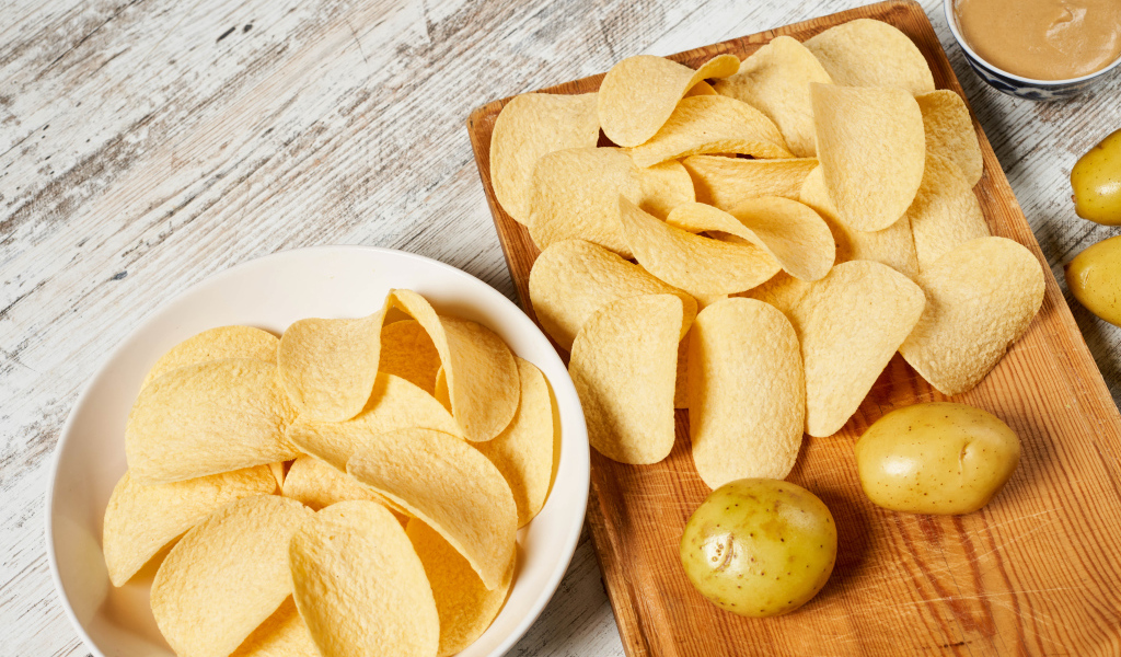 Чипсы на столе с картофелем 