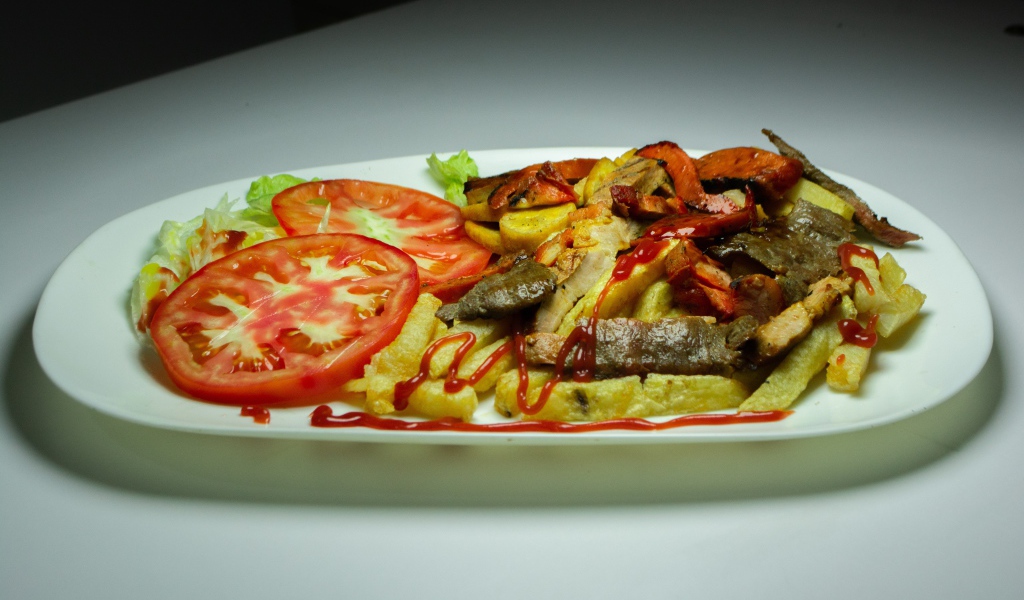 Картофель фри на тарелке с помидорами 