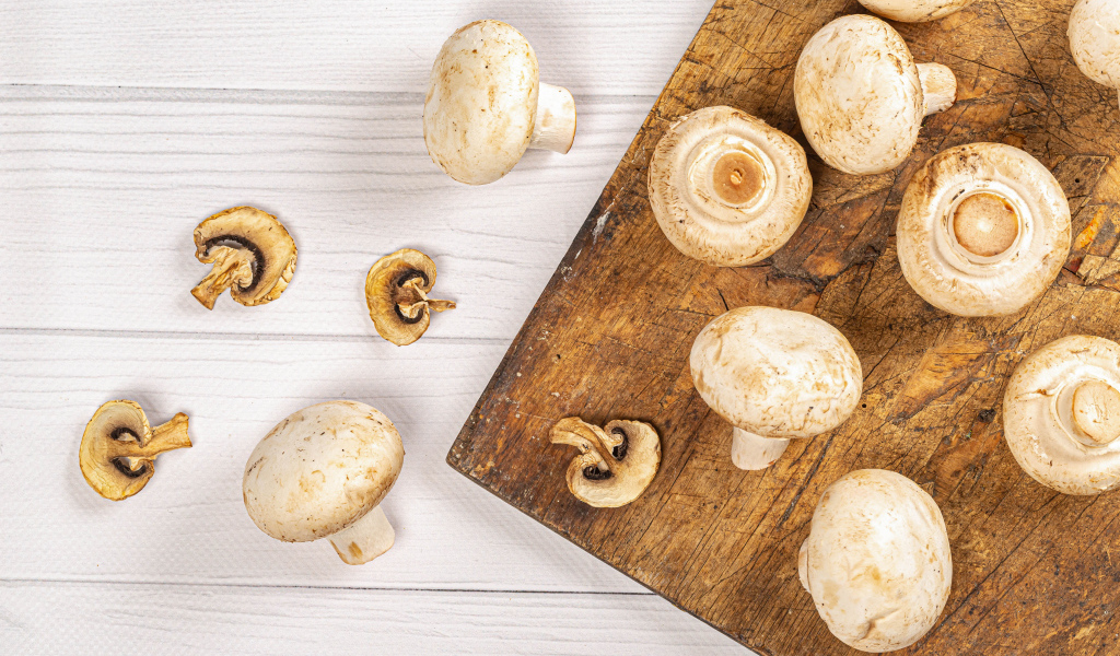 Свежие шампиньоны на разделочной доске