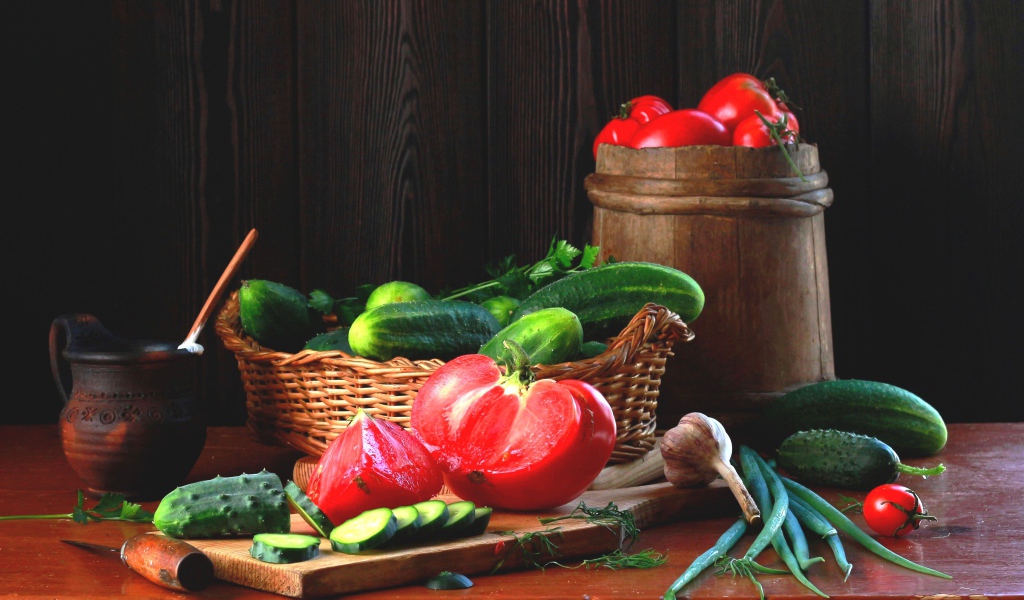 Свежие огурцы и помидора на столе с зеленым луком