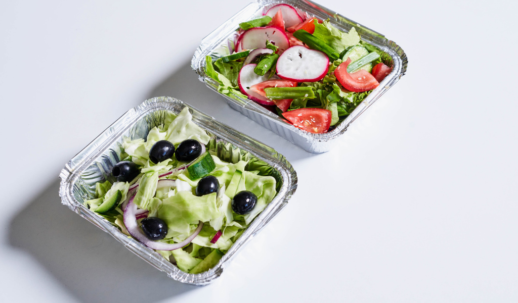 Салат из свежих овощей в тарелках на сером фоне 