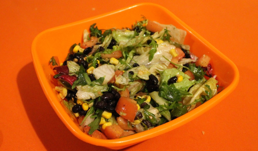 Салат из свежих овощей на оранжевом фоне