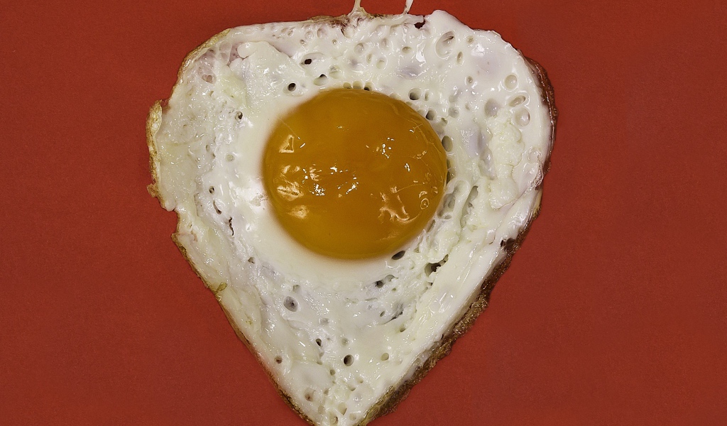 Яичница глазунья на красном фоне