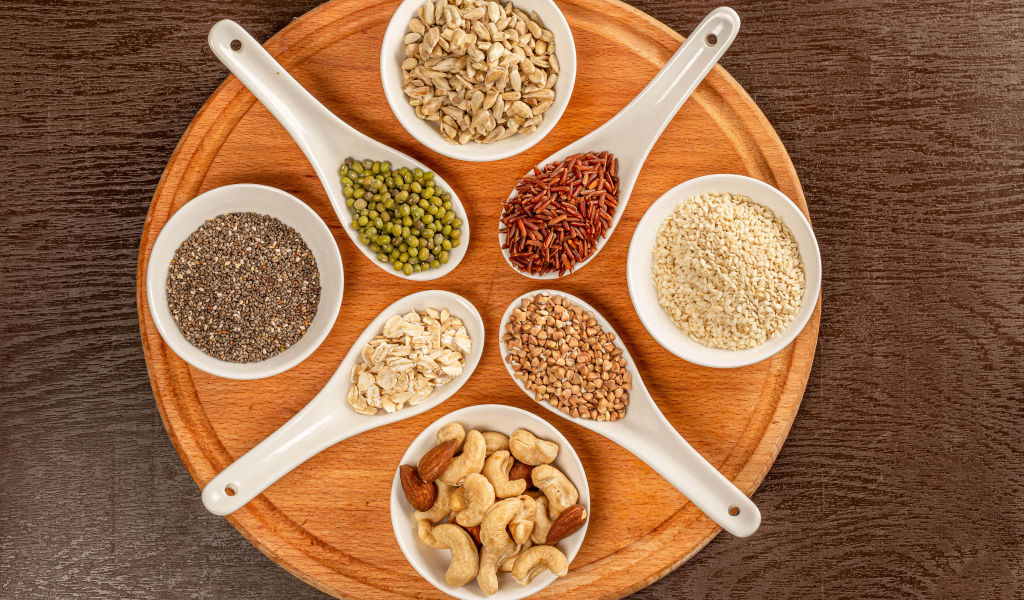 Зерна и орехи на доске на столе 