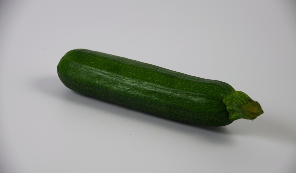 Зеленый кабачок на сером фоне