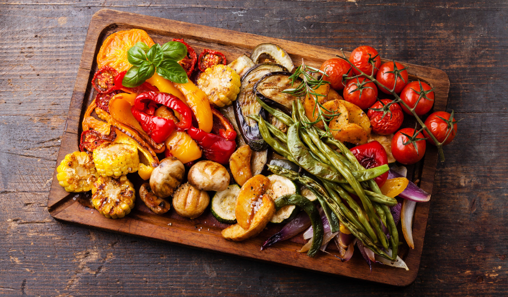 Запеченные на гриле овощи на разделочной доске 