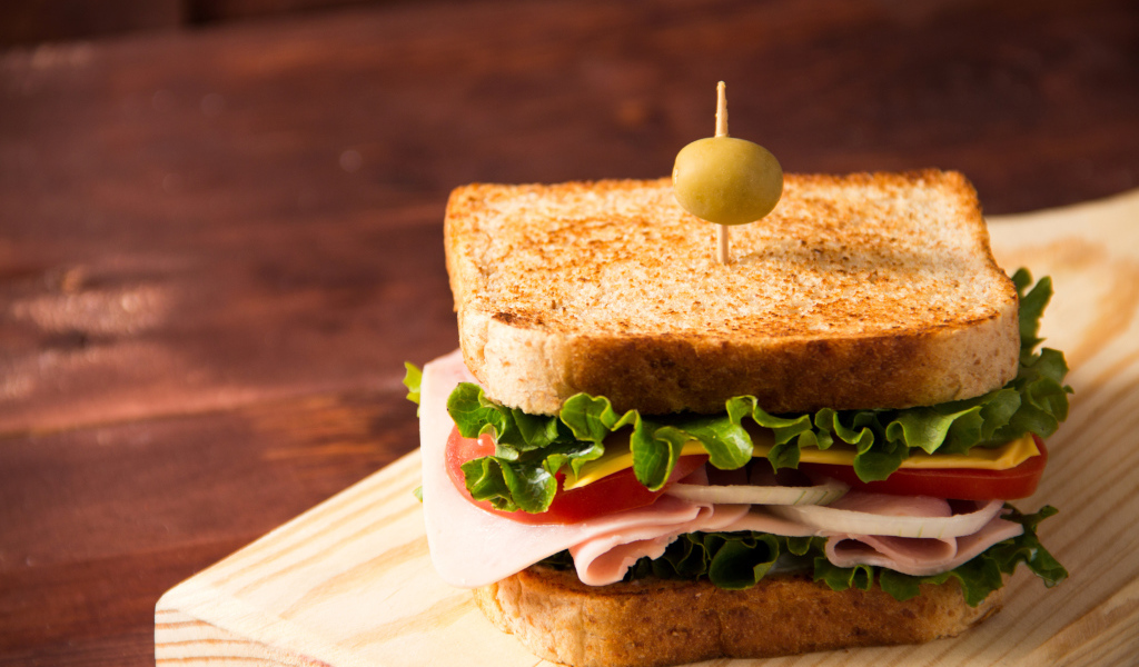 Гамбургер с ветчиной, помидорами, листьями салата и сыром