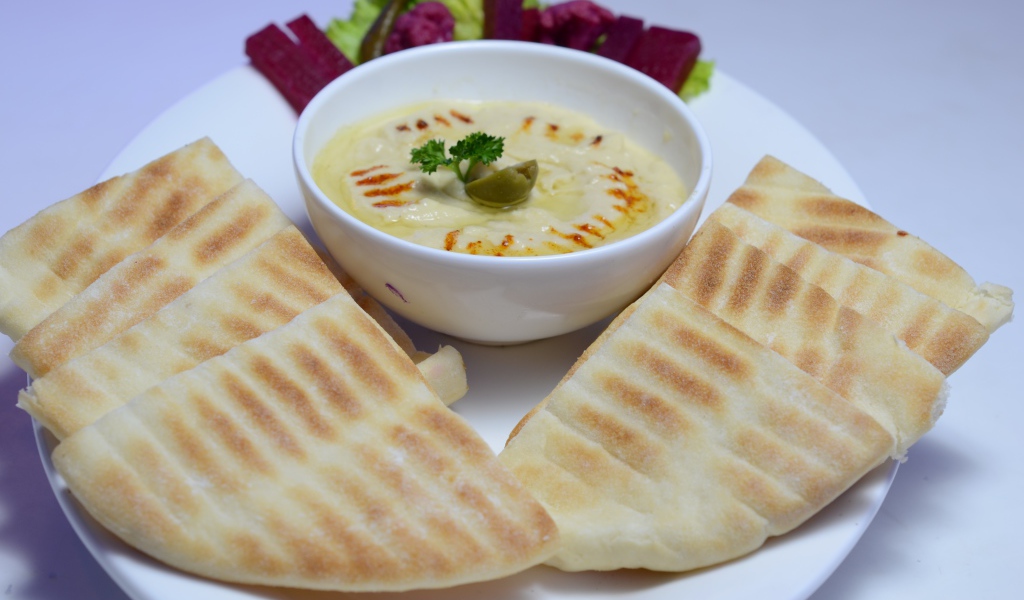 Хумус в белой тарелке с лавашом