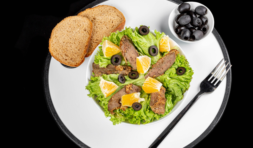 Листья салата с мясом на столе с хлебом