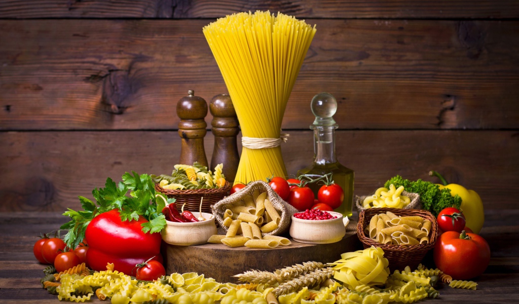 Много макаронных изделий на столе с овощами 
