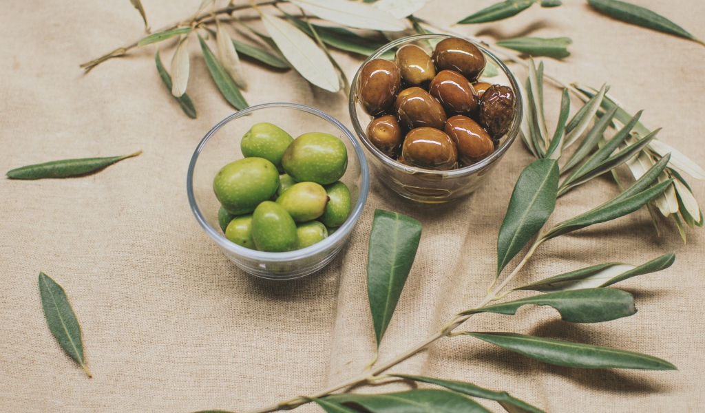 Оливки с ветками на серой ткани