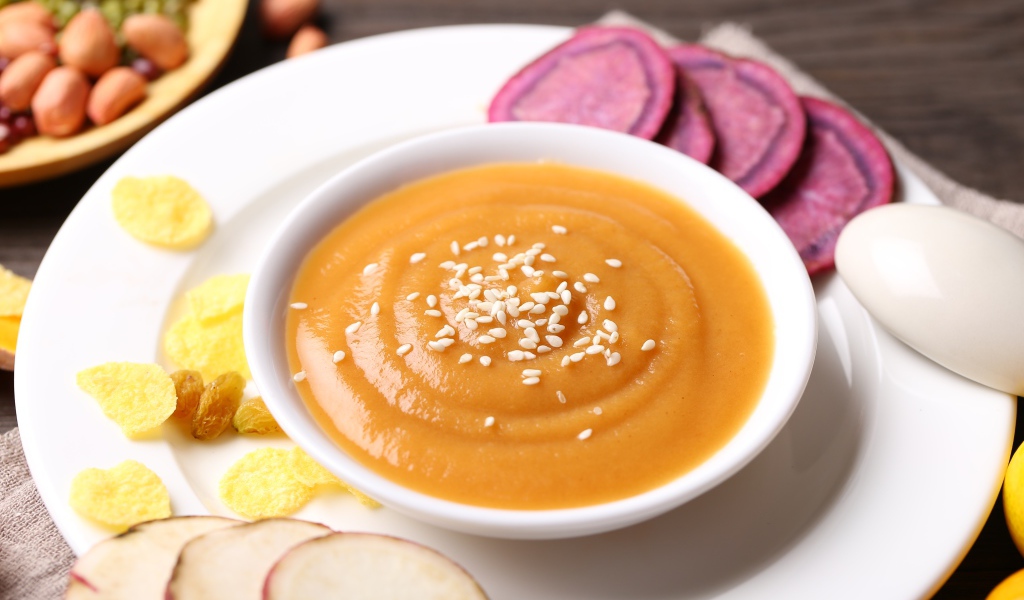 Гороховое пюре в белой тарелке с овощами