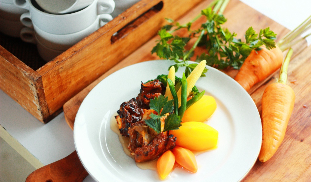 Картофель с морковью и мясом на белой тарелке 