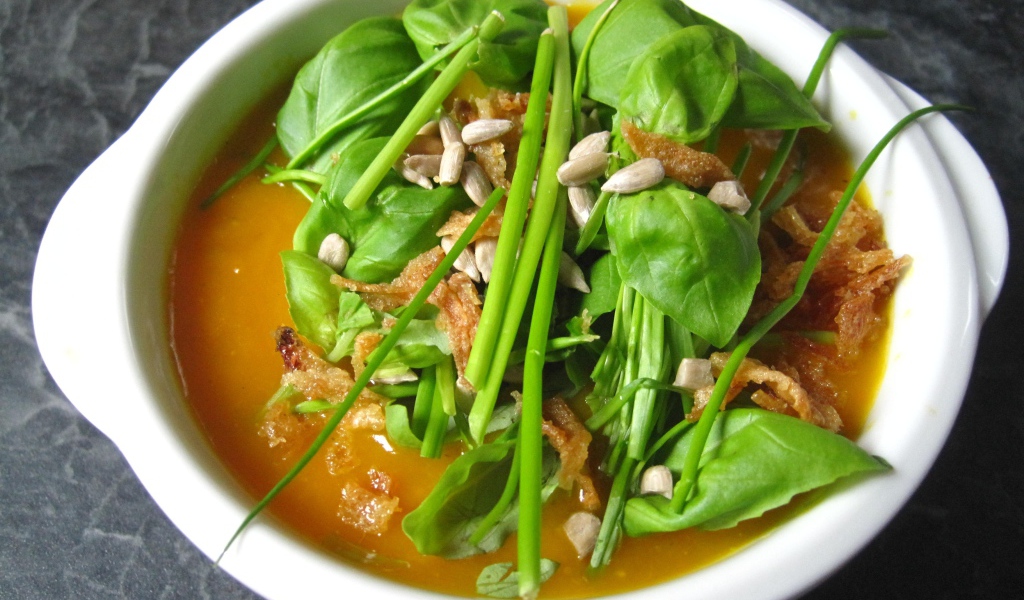 Тыквенный суп с зеленью в белой тарелке