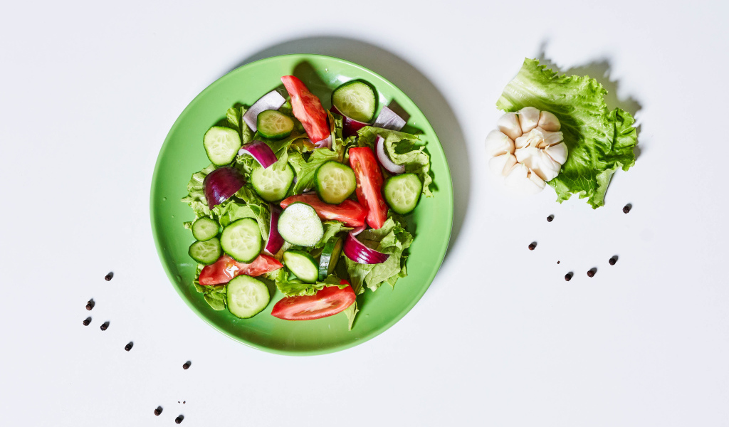 Салат с огурцами, луком, помидорами и листьями салата