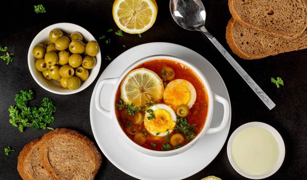 Солянка на столе  с хлебом и оливками 