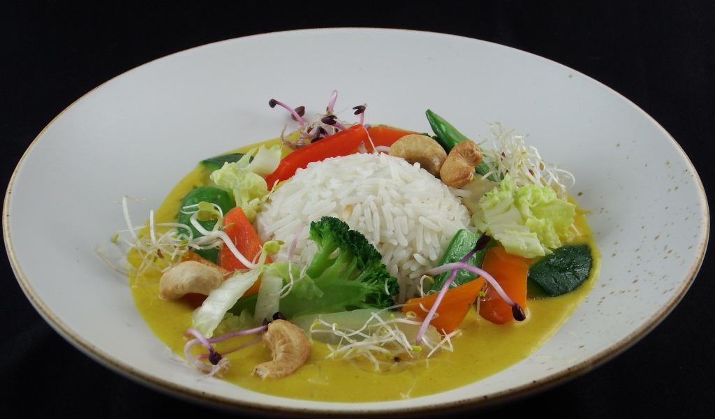 Вареный рис с овощами в большой белой тарелке