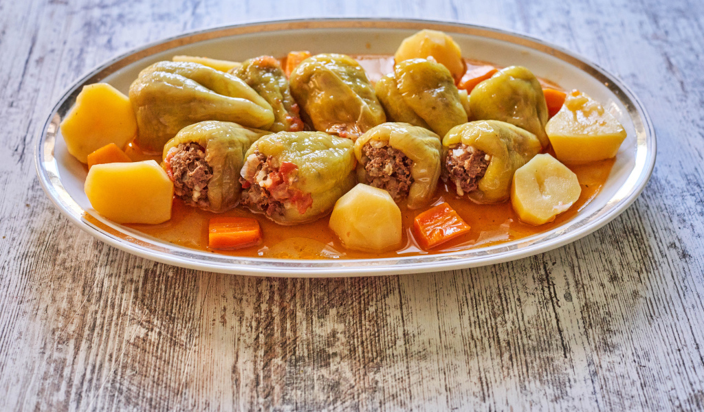 Фаршированный перец на тарелке с картофелем