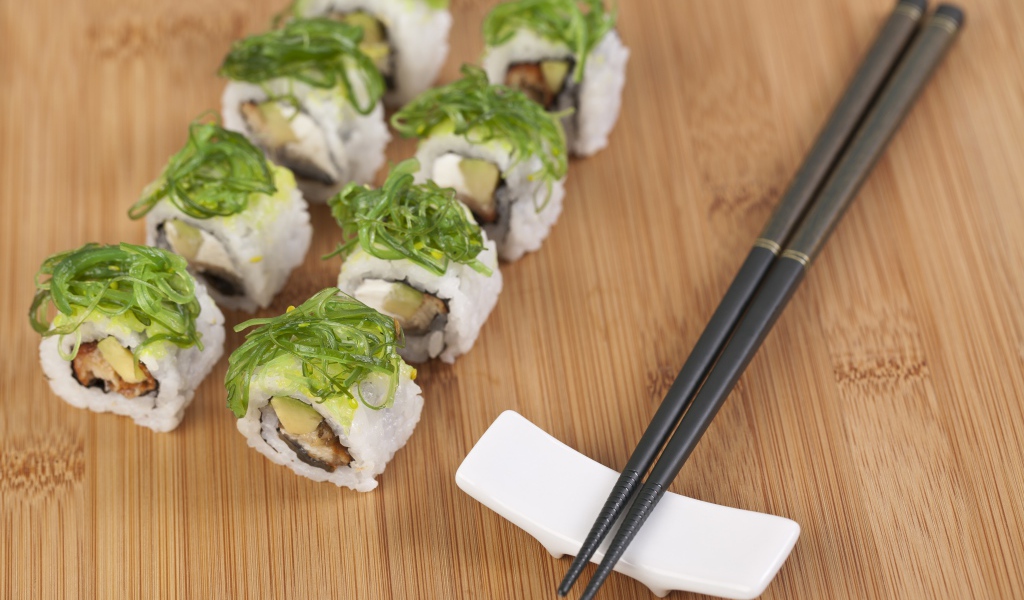 Суши с черными палочками на столе