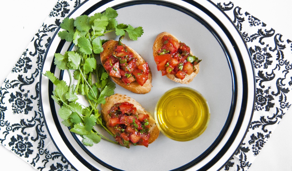 Бутерброды с помидорами на тарелке с петрушкой и маслом