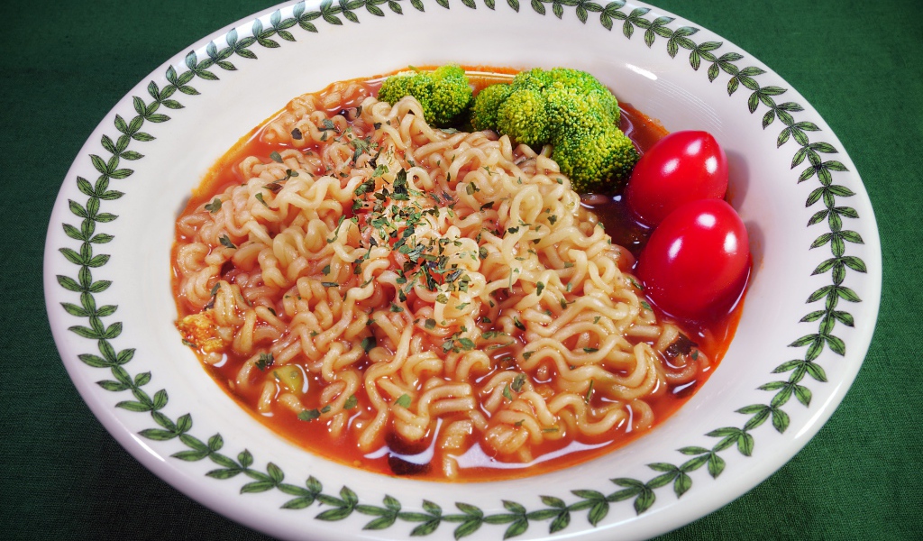 Вермишель с соусом в тарелке с помидорами