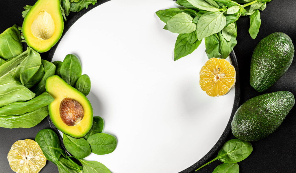 Авокадо с листьями базилика на белом фоне