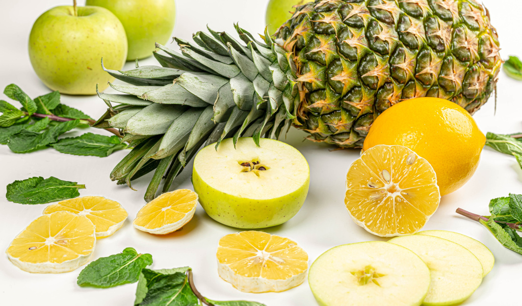 Зеленые яблоки на белом фоне с ананасом и лимоном