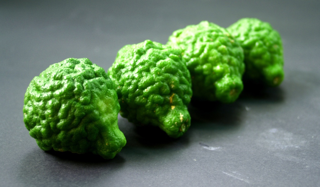 Зеленые плоды бергамота на серой поверхности