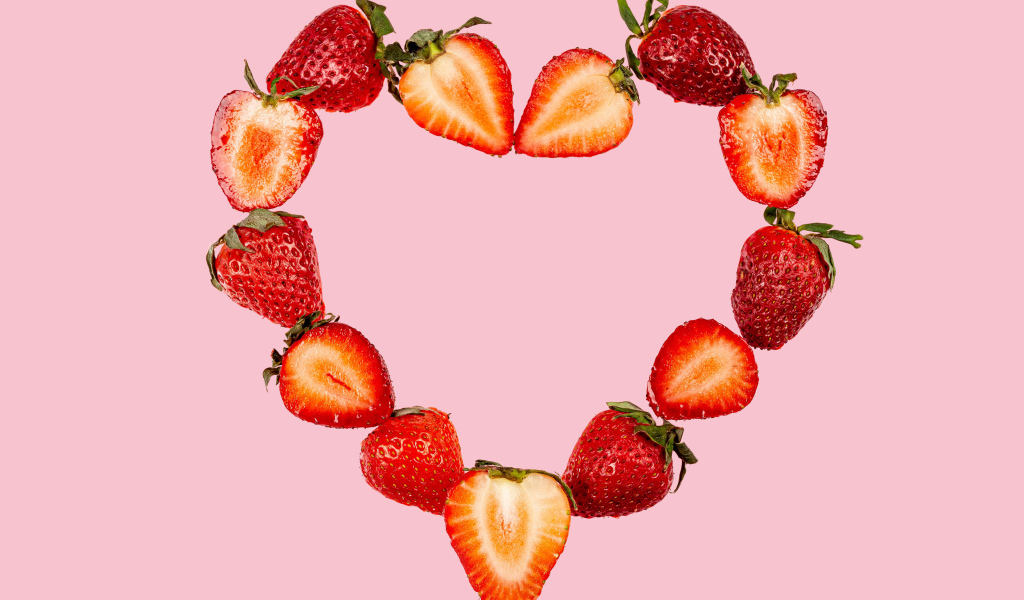 Сердце из клубники на розовом фоне 