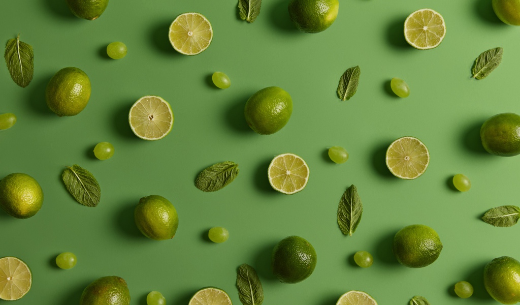 Лимоны и лаймы на зеленом фоне