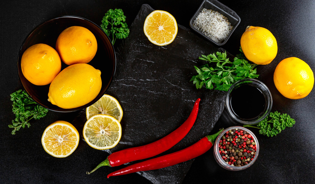 Лимоны на столе с красным перцем, петрушкой  и специями