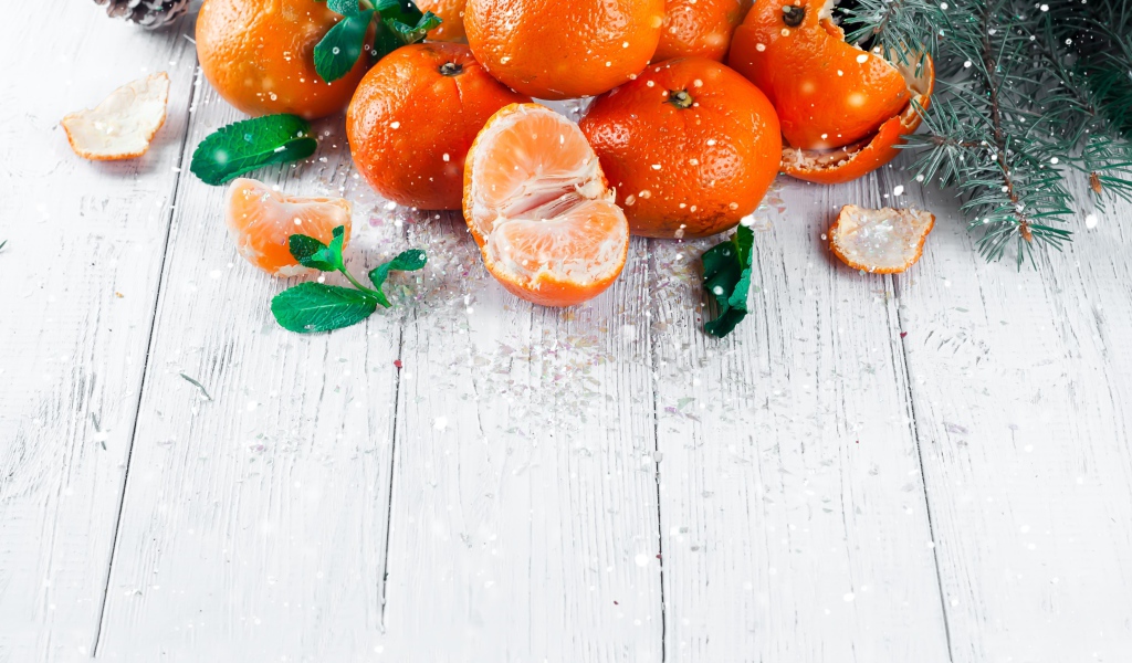 Спелые сочные мандарины с мятой на столе