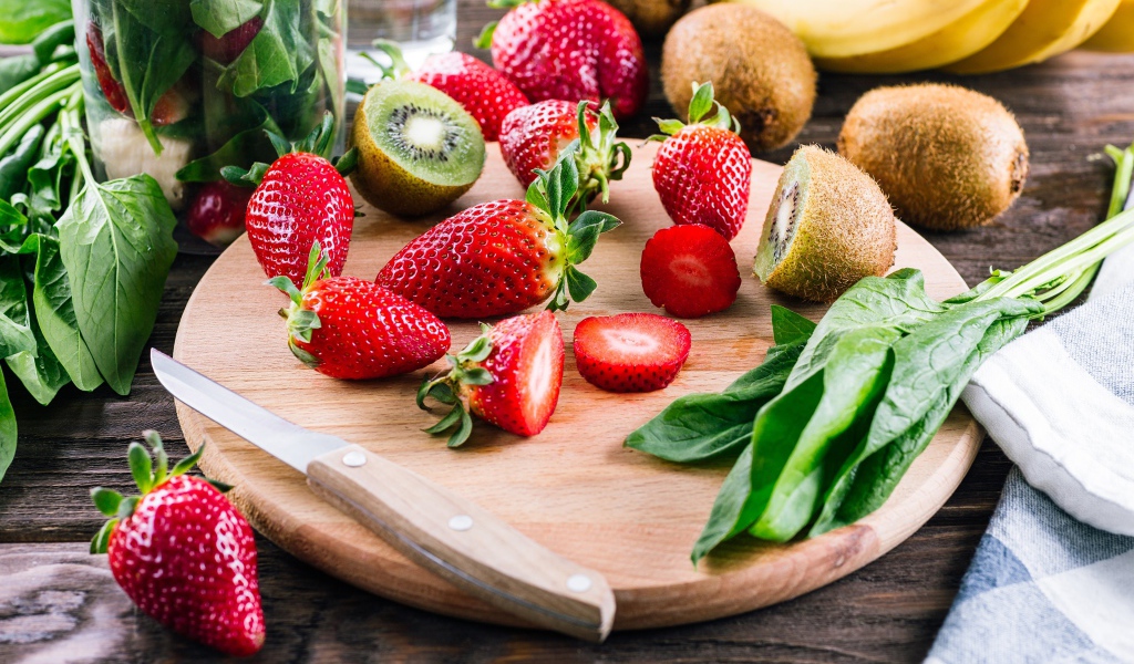 Нарезанная клубника и киви на деревянной доске 