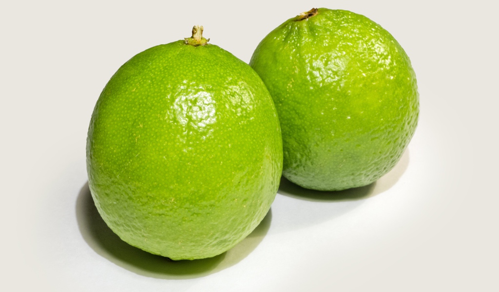 Два больших зеленых лайма на столе