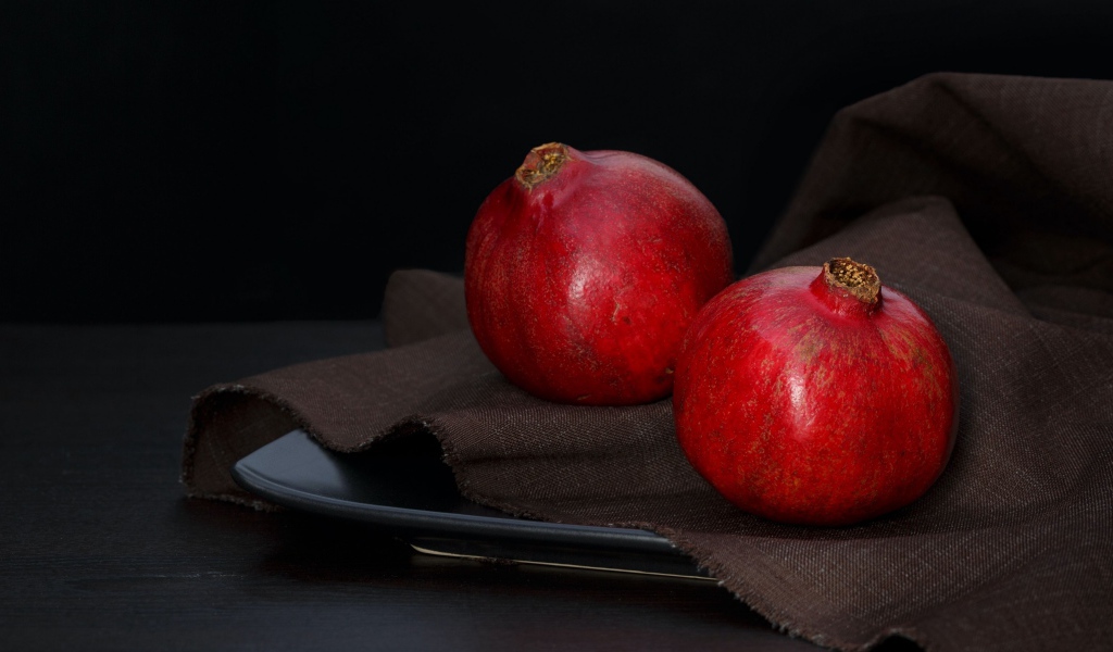 Два красных граната на столе