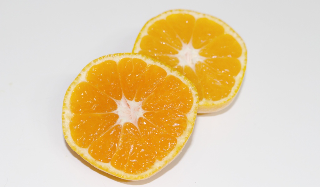 Два кружочка мандарина на сером столе 