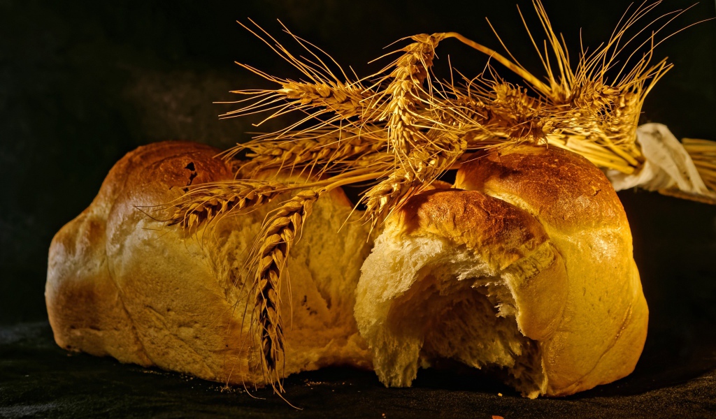 Свежий хлеб с колосьями пшеницы на столе