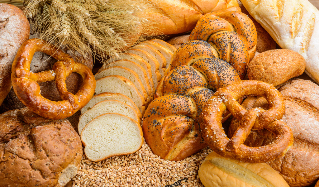 Свежая выпечка на столе с колосьями и зернами пшеницы 