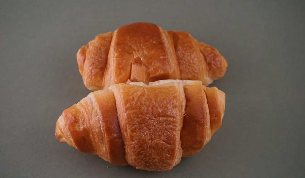 Два свежих круассана на серой поверхности