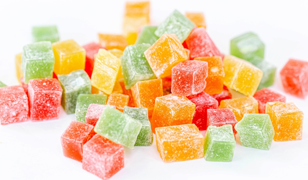 Аппетитный разноцветный мармелад в сахаре на белом фоне 