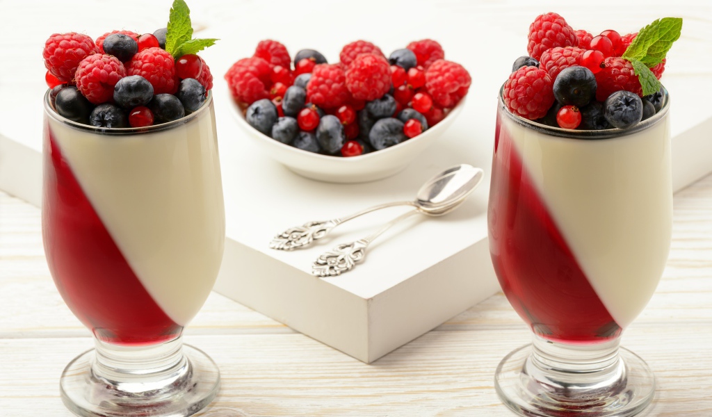 Двухцветный десерт с ягодами на столе 