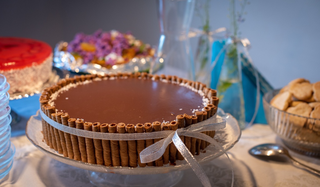 Большой шоколадный торт с трубочками на столе