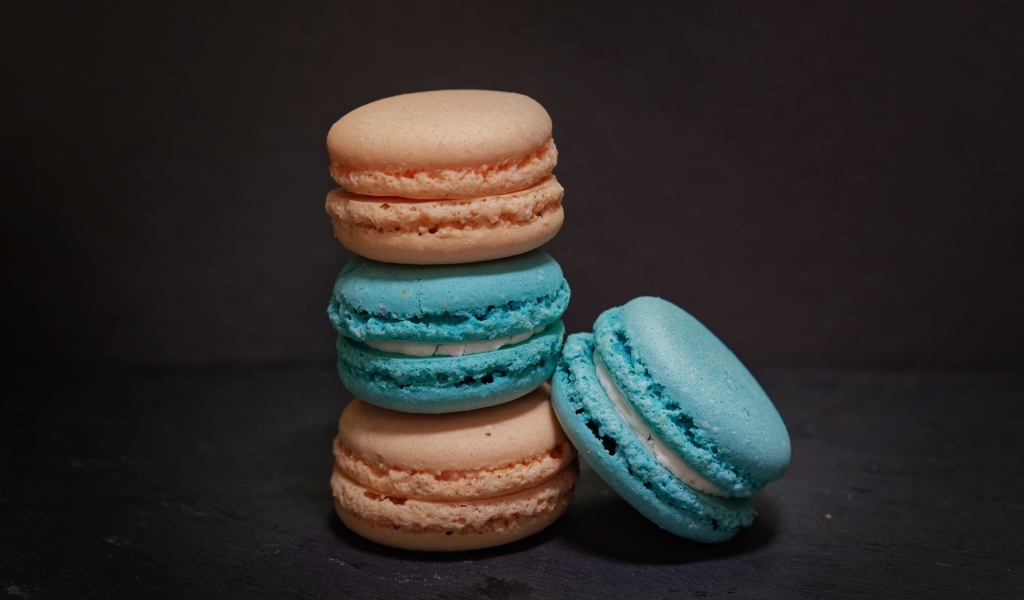 Голубой и коричневый десерт макарун на сером фоне