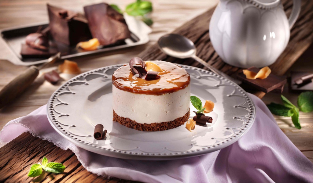 Пирожное на большой круглой тарелке на столе с шоколадом