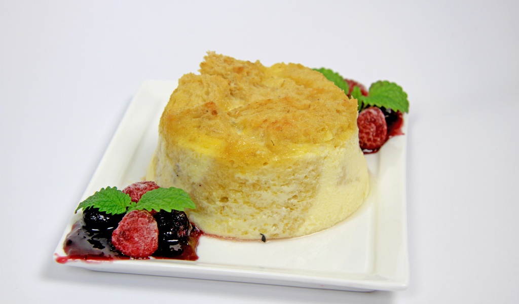 Пирожное на большой белой тарелке с ягодами