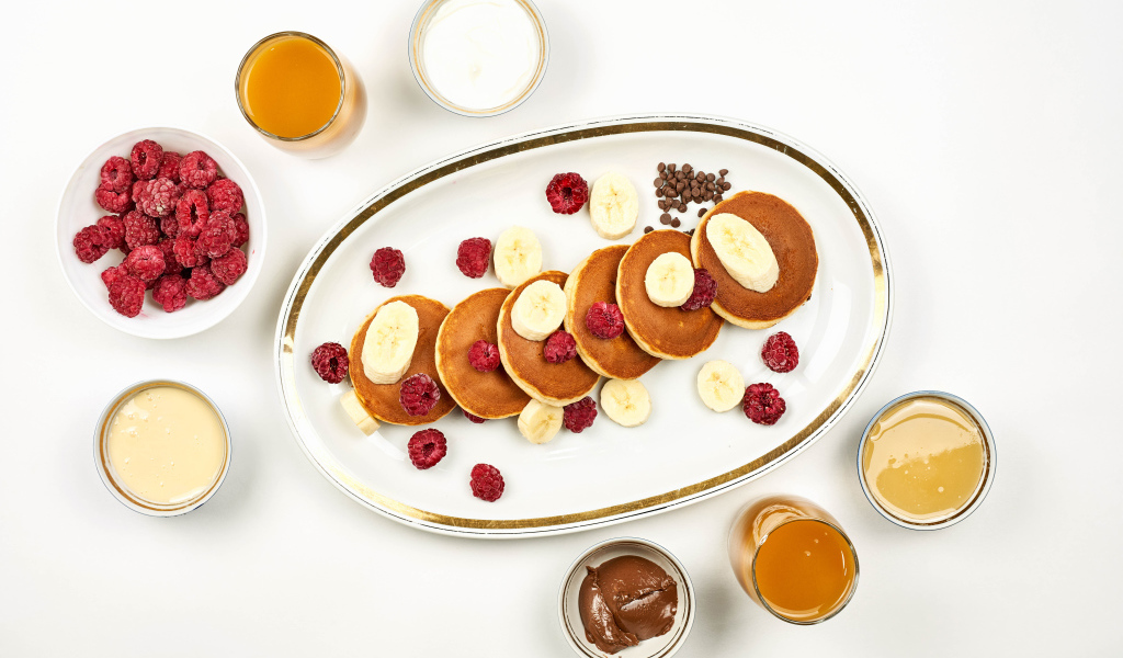 Сырники на столе с малиной и сладкими начинками